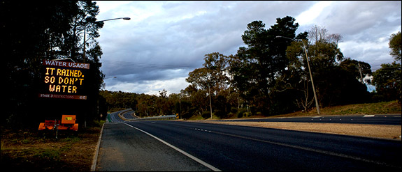 It rained, so don't water: A roadside sign tells drivers near Canberra, the nation's capital. Use left and right arrows to navigate through all images.