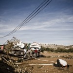A man prays near an emergency water tanker at a filling point.