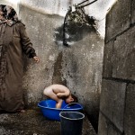 In a village with no central water supply, a boy bathes.