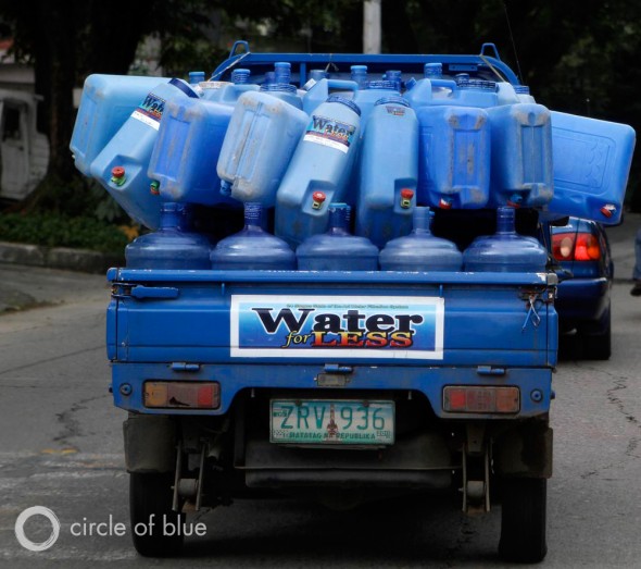 A truck carries refillable water containers in Manila. Refillable water containers Manila east Zone philippines privatization slum cuatro squatter village truck