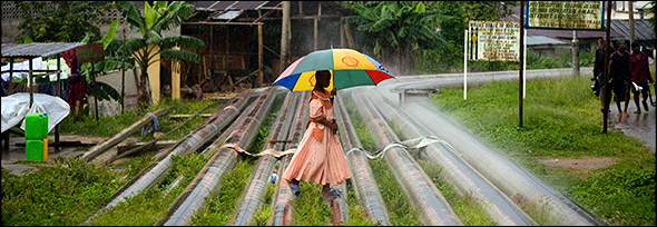 Oil pipelines create a pathway for this young woman through the village of Okrika Town, Nigeria. Photo by Ed Kashi.