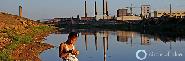 A Chinese boy fishes with his family on the shores of the Yellow River in Huijihe, west of Baotou in Inner Mongolia. The river carries effluent from the paper mills and fertilizer factories lined on its banks and along its tributaries in this heavily industrialized region of China. Photo © 2009 Greg Girard/Contact Press Images for Circle of Blue. Click image to enlarge.
