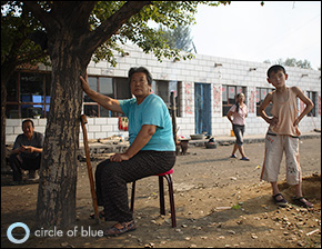 Yangxiumei, 59, sits in front of her house near Baogang, Inner Mongolia. Like many others in her village, she suffers from a debilitating bone disease that has made her leg go lame. Many locals believe that their health problems are caused by polluted water. Click image to enlarge.