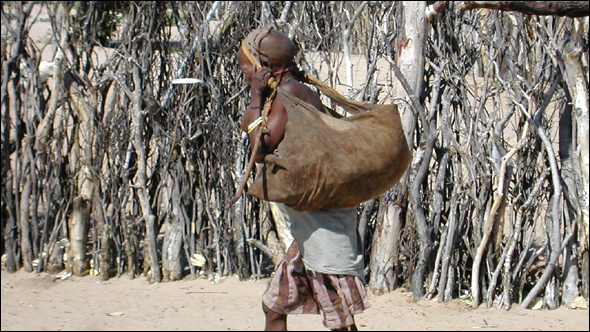 Kgaga bringing supplies to her hut.