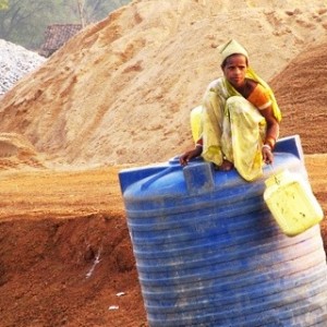 A water transport construction worker rests atop a bulk water container near Tilda, northwest of Raipur in Chhattisgarh, India.