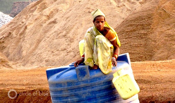 A water transport construction worker rests atop a bulk water container near Tilda, northwest of Raipur in Chhattisgarh, India.
