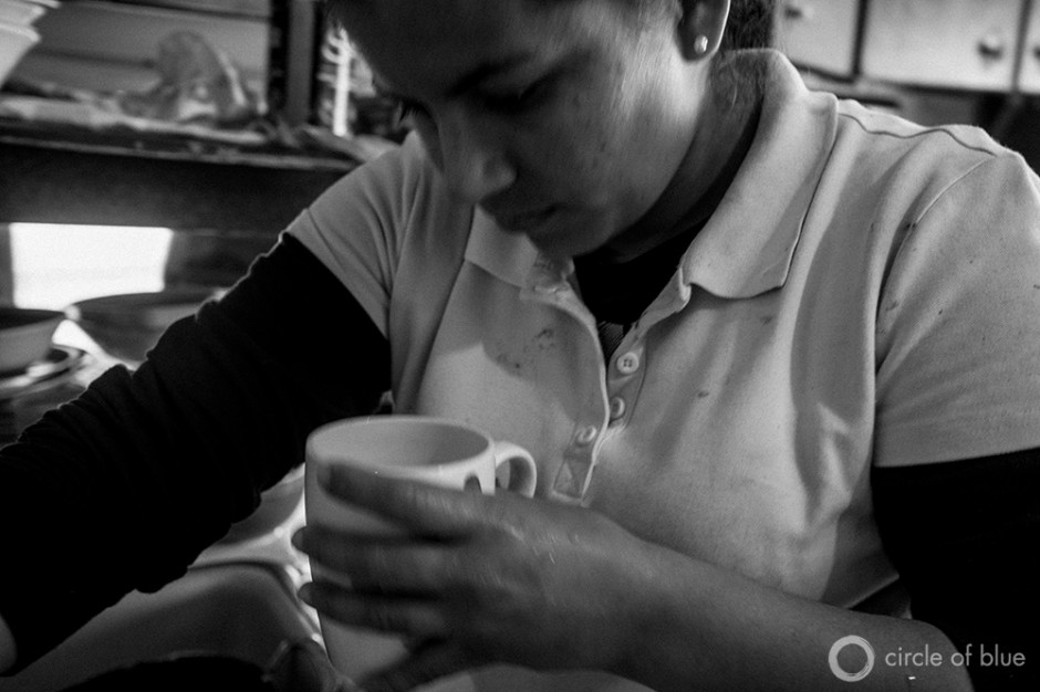 Evilia Robles inspects drinking water at her home in Alpaugh. The small farmworker community in California's Central Valley suffers from high levels of arsenic and other contaminates in its water.
