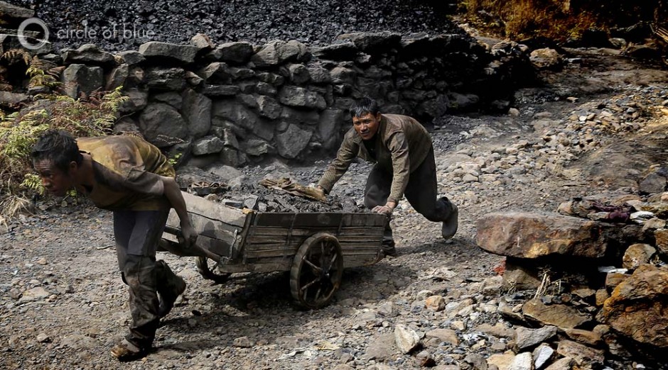 Two miners drag a cart of coal out of a rathole mine south of Shillong. The coal face is at the end of a tunnel over one kilometer long. It takes miners an hour to trudge to the coal face, an hour to mine and fill the cart, and an hour to pull the cart with $2 worth of coal back to the mine entrance. 