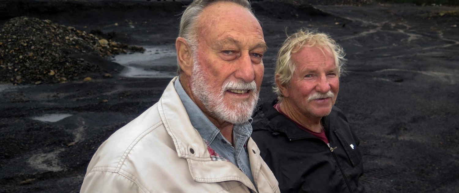 At the site of an abandoned coal mine near Vryheid, Gerrie Beukes (left) and Hugo Joubert (right) explain the damage to land and water that occur at unreclaimed mines. "I'll fight any new mine with everything I have. It's just a mess," Beukes said. Photo © Keith Schneider / Circle of Blue 