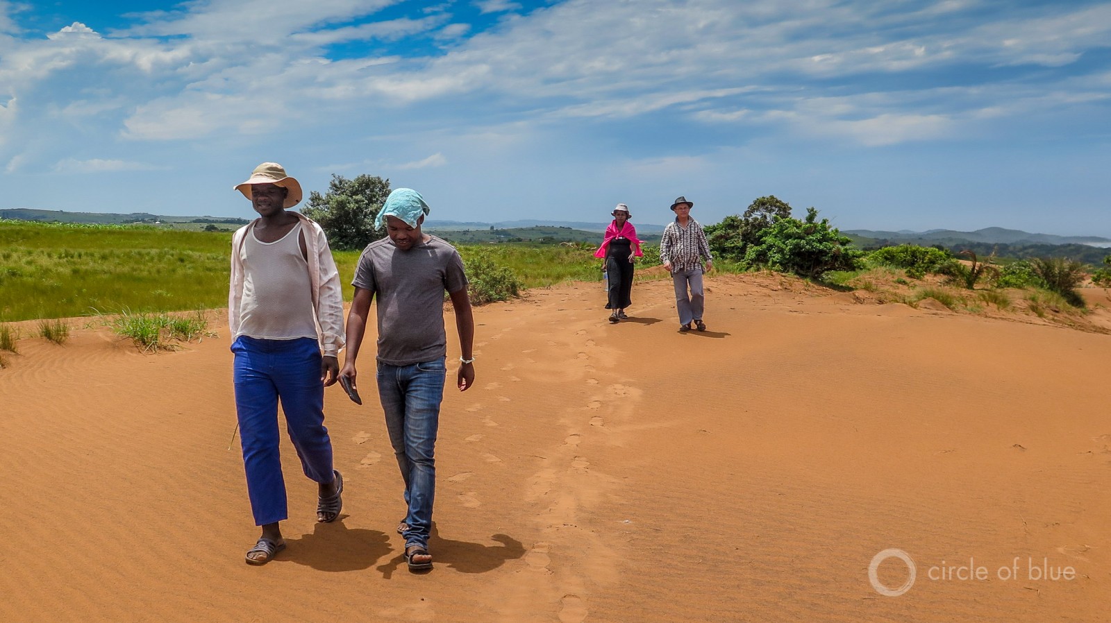 Three leaders of the Amadiba Crisis Committee, which has opposed beach mining and a new national highway since the group’s founding in 2007, tour the area of the proposed mine in January. From left to right they are Zwelidumile Yalo, Mzamo Dlamini and Nonhle Mbuthuma. Dick Forslund, far right, is Mbuthuma's husband. Photo © Keith Schneider / Circle of Blue