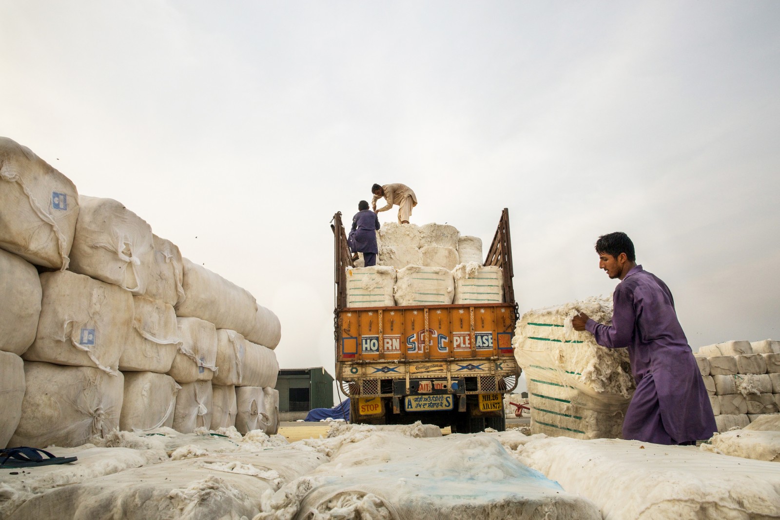 Workers unload cotton bales at the Wagah-Attari Cargo Terminal on the border of India and Pakistan. Dry conditions in Pakistan during the past year wilted crops and forced the textile industry to import $US 4 billion of cotton. Photo courtesy Asian Development Bank via Flickr Creative Commons 