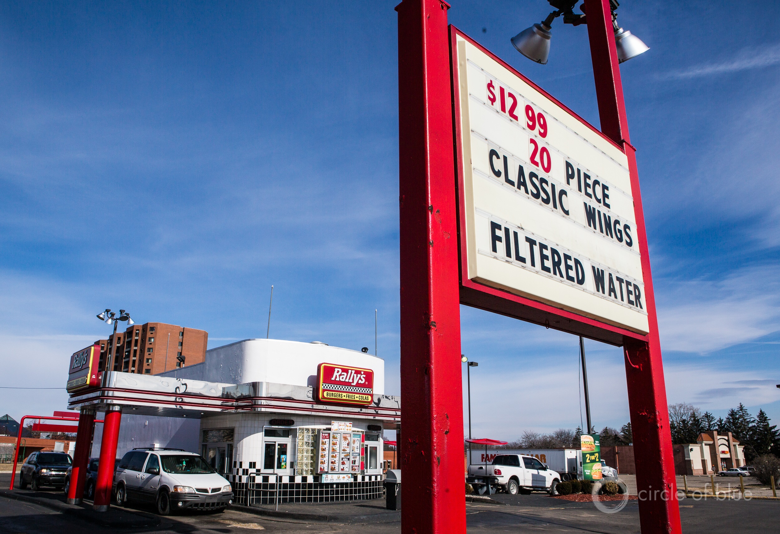 A sign at a Rally's fast food restaurant in Flint, Michigan advertises filtered water. A sensible water quality solution for individuals or businesses, water filters are a challenge for utilities to deploy. Photo © J. Carl Ganter / Circle of Blue